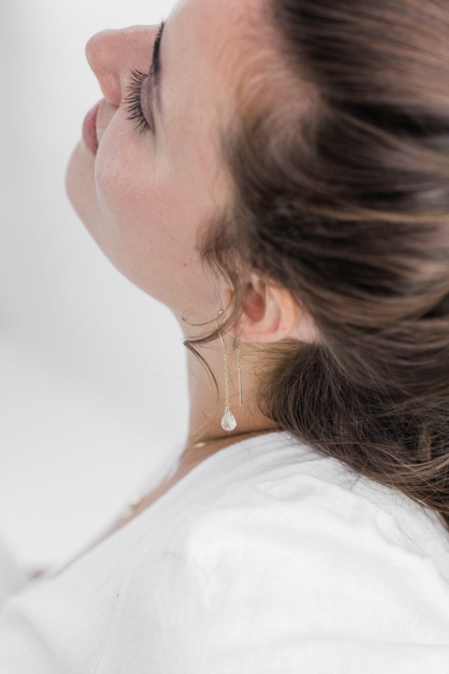 Close up of woman wearing Guardian Clear Quartz Threader earring