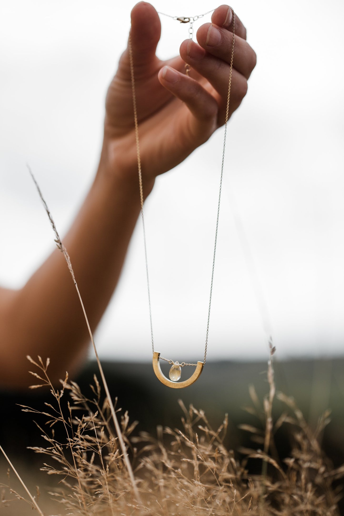 Hand holding Guardian Crescent Clear Quartz Drop Necklace