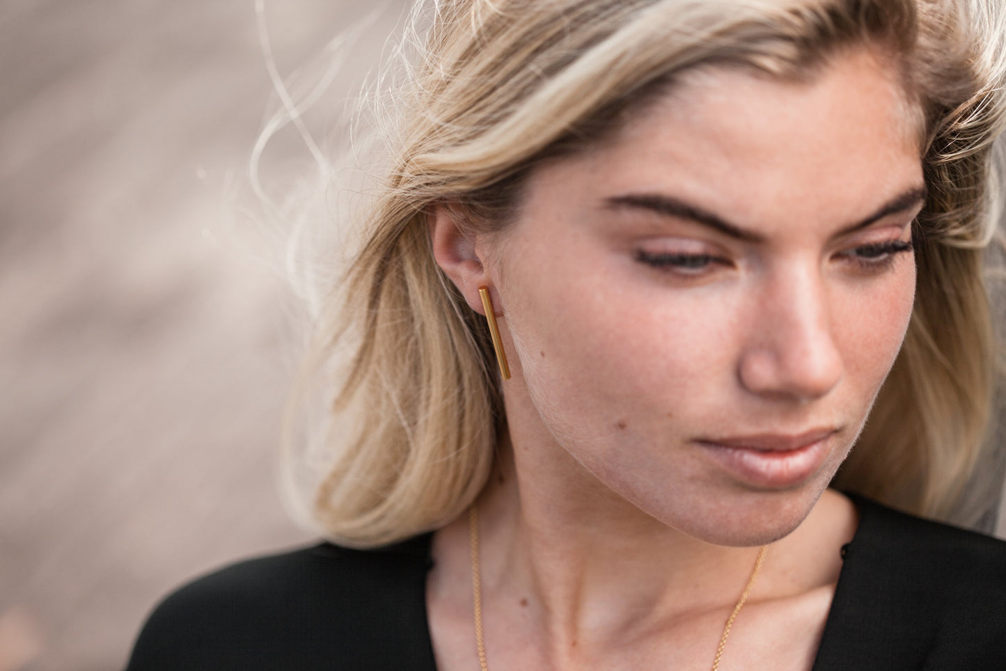 Close up of woman wearing Audrey Long Bar Stud earring