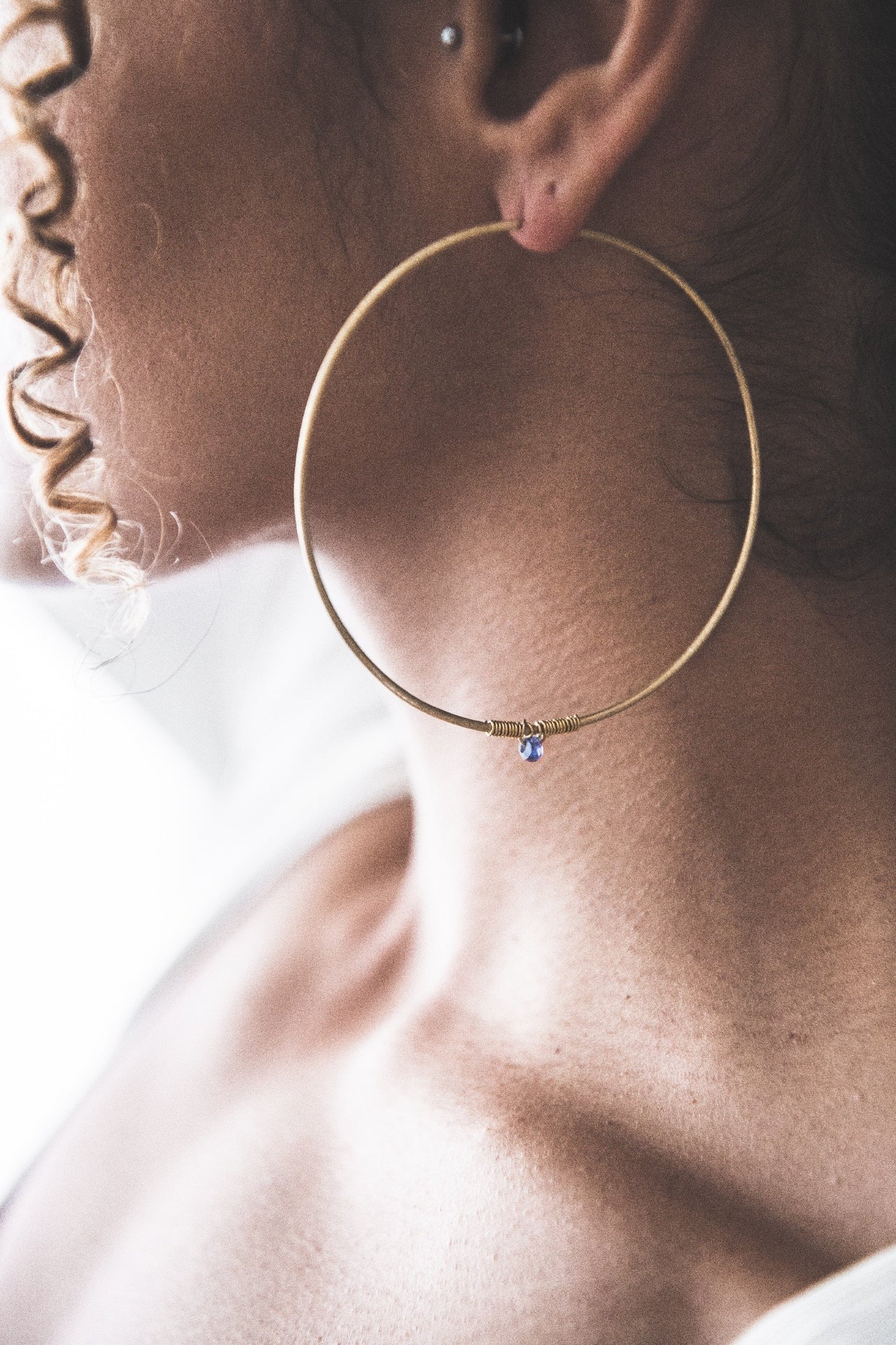 Close up of woman wearing Bejewelled Water Sapphire Hoop - Large