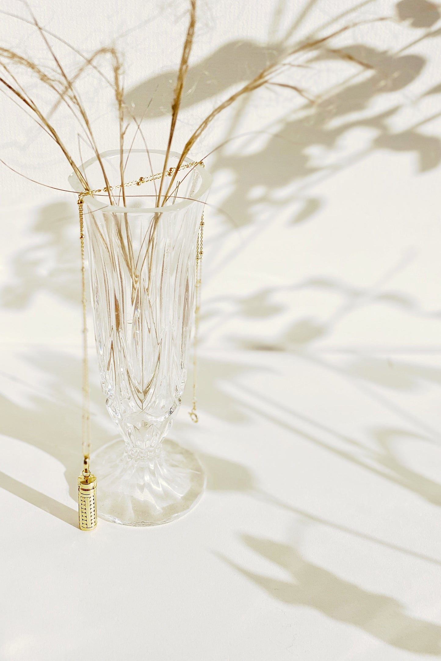 Lexi Wishing Locket with chain draped over vase