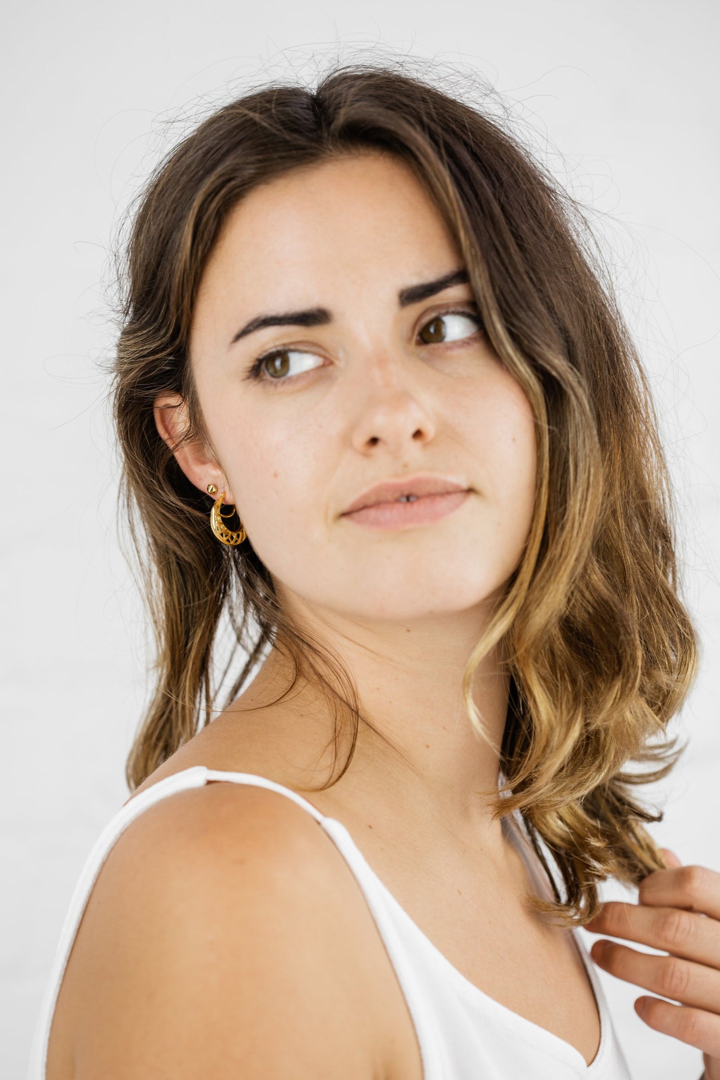 Close up of woman wearing Jameela Open Round Hoop earring